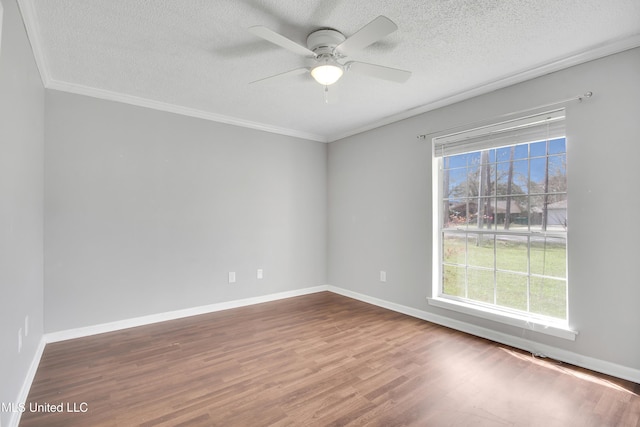 spare room featuring ornamental molding, a ceiling fan, a textured ceiling, wood finished floors, and baseboards