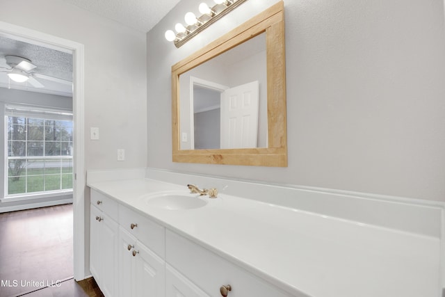 bathroom with a ceiling fan, a textured ceiling, and vanity