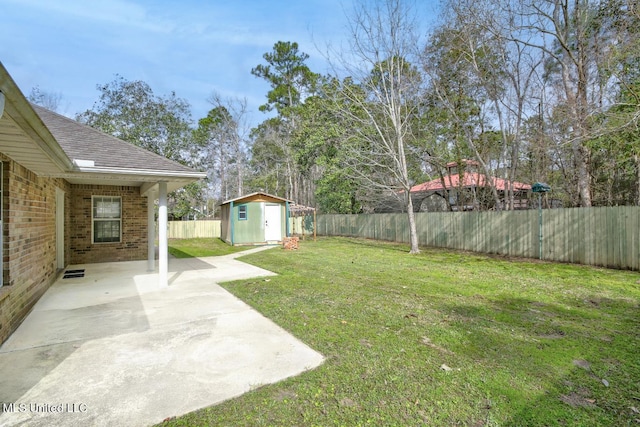 view of yard with an outbuilding, a shed, a patio, and a fenced backyard