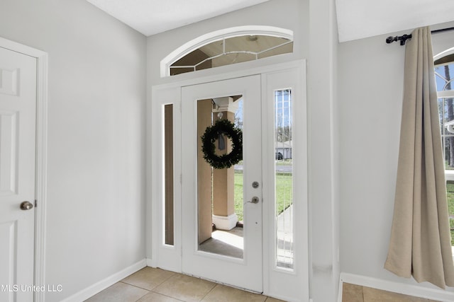 entryway with baseboards and light tile patterned flooring