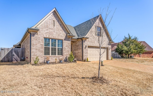 view of front of house with concrete driveway, brick siding, and fence