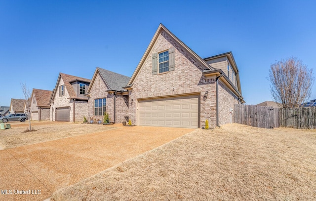 view of front of house featuring a garage, brick siding, fence, and driveway