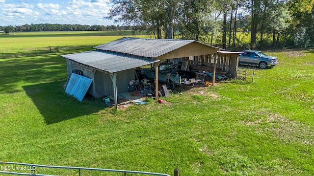 view of outdoor structure featuring a lawn and a rural view