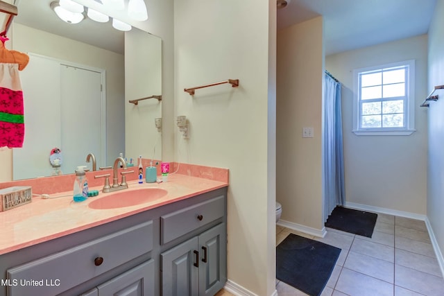 bathroom with tile patterned flooring, vanity, and toilet