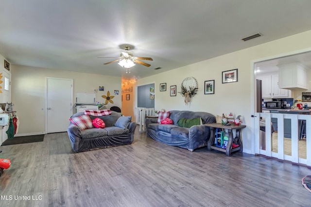 living room with hardwood / wood-style flooring and ceiling fan