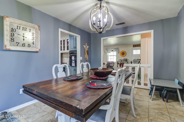 tiled dining room with an inviting chandelier