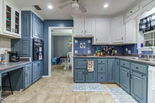 kitchen with white cabinets, backsplash, stainless steel appliances, and blue cabinets