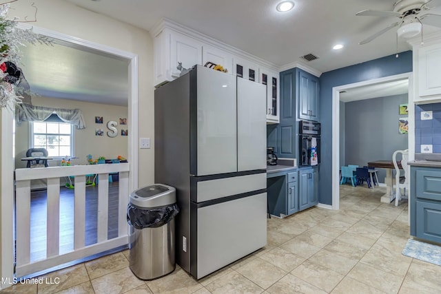 kitchen featuring blue cabinetry, stainless steel refrigerator, ceiling fan, oven, and white cabinets