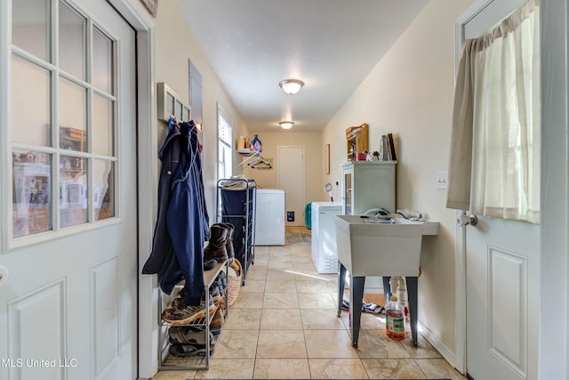 laundry area with separate washer and dryer and light tile patterned floors