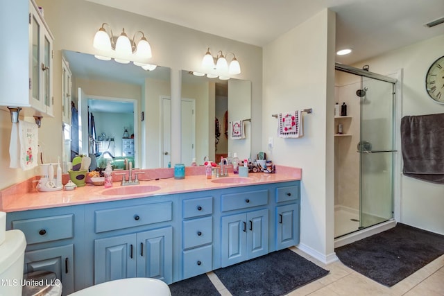 bathroom featuring tile patterned flooring, vanity, and a shower with door