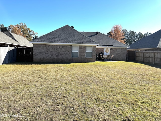 rear view of house featuring a yard