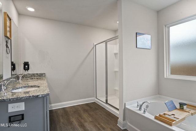 full bathroom with a garden tub, a sink, a shower stall, and wood finished floors