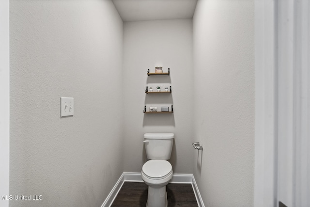 bathroom with toilet, baseboards, and wood finished floors