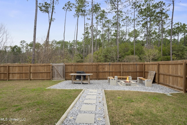 view of yard with a gate, a fire pit, and fence