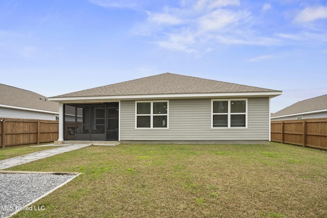 rear view of property featuring a sunroom, a fenced backyard, a yard, and roof with shingles