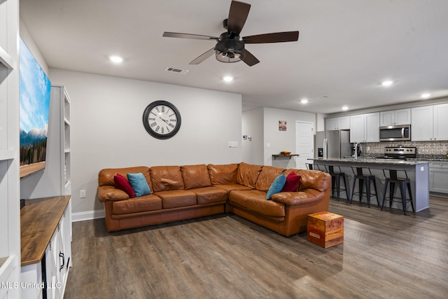 living area featuring a ceiling fan, dark wood-style flooring, visible vents, and recessed lighting