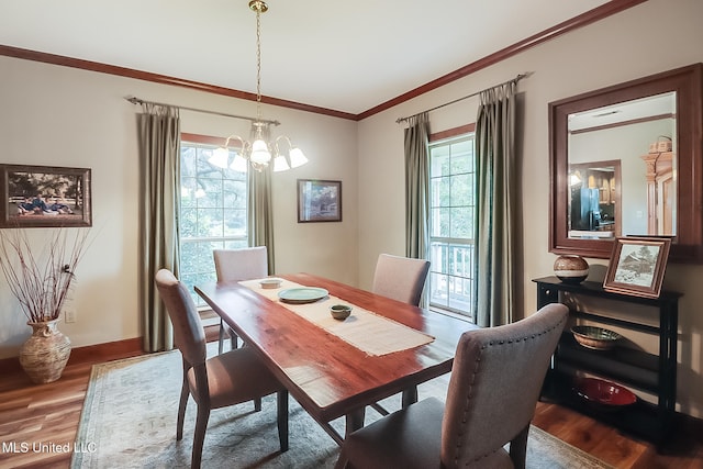 dining space with a wealth of natural light, hardwood / wood-style floors, crown molding, and an inviting chandelier