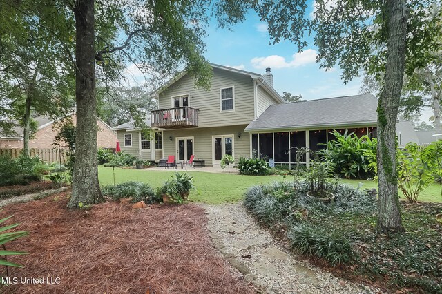 rear view of house featuring a lawn, a sunroom, a balcony, and a patio