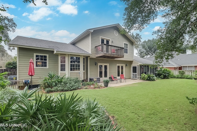 back of house featuring a yard, a balcony, a patio, and a sunroom