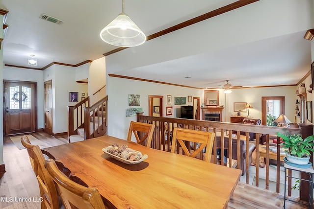 dining space featuring ceiling fan, plenty of natural light, ornamental molding, and light wood-type flooring