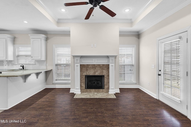 unfurnished living room featuring a wealth of natural light and dark wood-type flooring