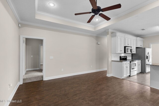 kitchen featuring stainless steel appliances, a raised ceiling, white cabinets, and dark wood-style floors