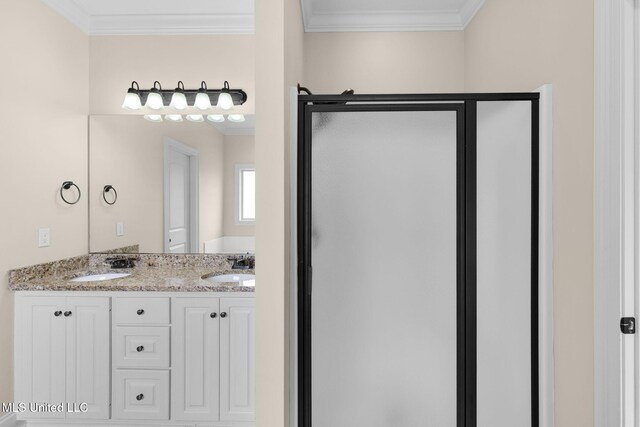 full bathroom with double vanity, ornamental molding, a stall shower, and a sink