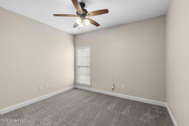 carpeted spare room featuring a ceiling fan and baseboards