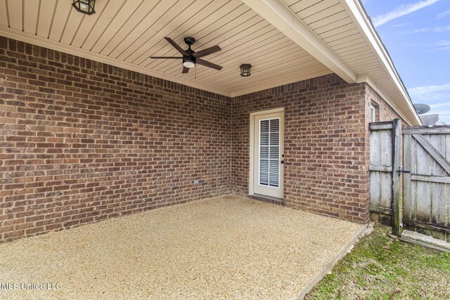 view of patio featuring a gate, fence, and a ceiling fan