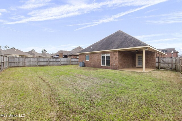 back of house featuring a fenced backyard, a patio, a lawn, and brick siding