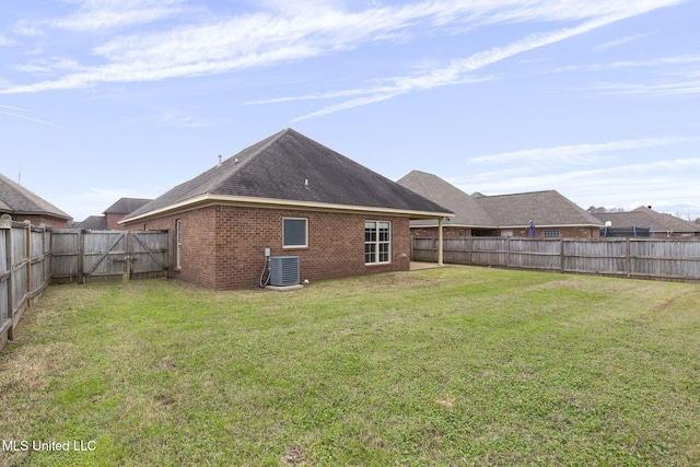 rear view of house with brick siding, a lawn, a gate, central AC, and a fenced backyard