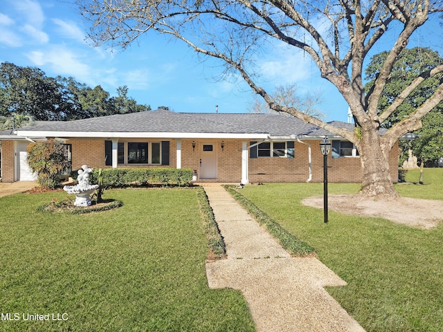 ranch-style home featuring brick siding, an attached garage, a front lawn, and roof with shingles