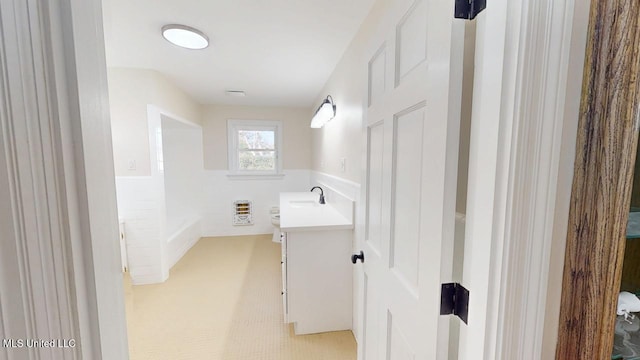 bathroom with wainscoting, vanity, and heating unit