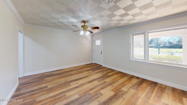 empty room featuring light wood finished floors, ceiling fan, ornamental molding, and baseboards