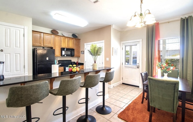 kitchen with ornamental molding, black appliances, light tile patterned flooring, decorative light fixtures, and a chandelier