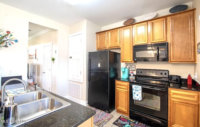 kitchen with dark stone counters, sink, black appliances, crown molding, and light tile patterned floors