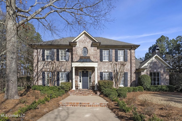 colonial inspired home with brick siding