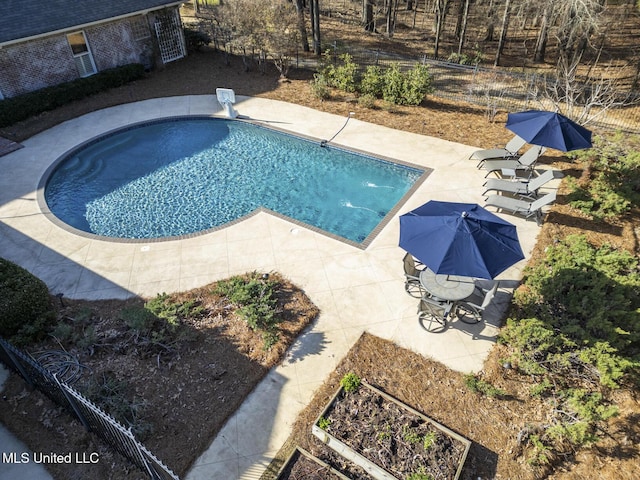 view of swimming pool with a diving board, a patio area, and fence