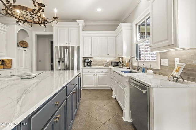 kitchen featuring appliances with stainless steel finishes, gray cabinets, white cabinetry, and a sink