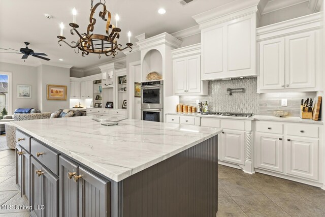 kitchen with stainless steel appliances, white cabinets, crown molding, and backsplash