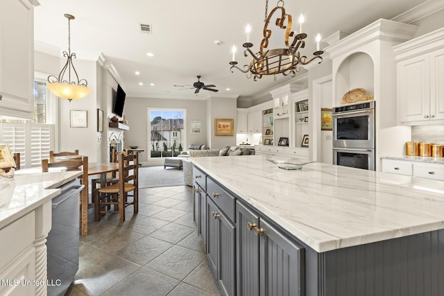 kitchen with appliances with stainless steel finishes, white cabinets, visible vents, and ornamental molding