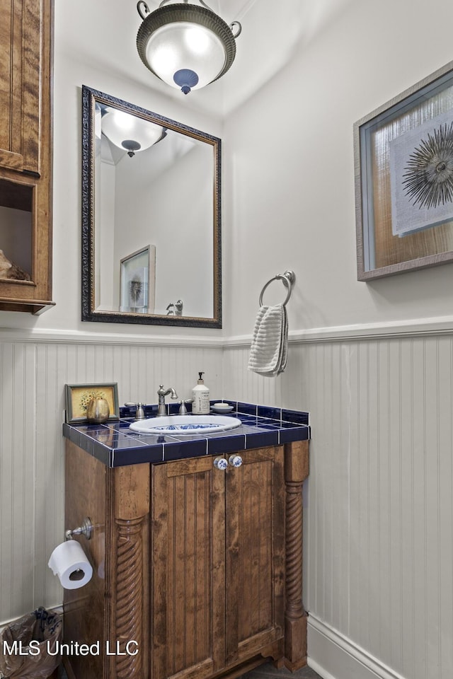 bathroom featuring a wainscoted wall and vanity