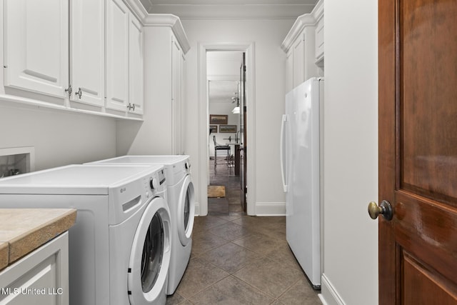 laundry area with washer and clothes dryer, tile patterned flooring, cabinet space, and baseboards