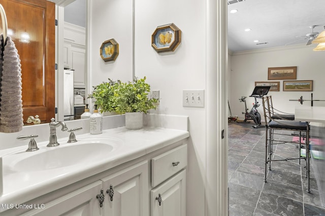 bathroom with recessed lighting, visible vents, ornamental molding, stone finish floor, and vanity