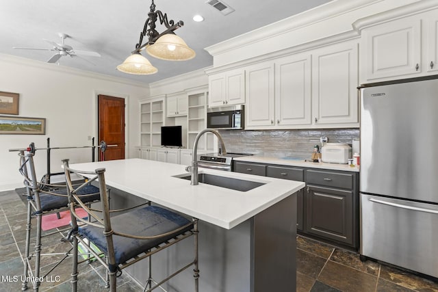 kitchen with crown molding, stainless steel appliances, visible vents, decorative backsplash, and a sink