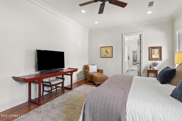 bedroom featuring baseboards, visible vents, wood finished floors, and ornamental molding