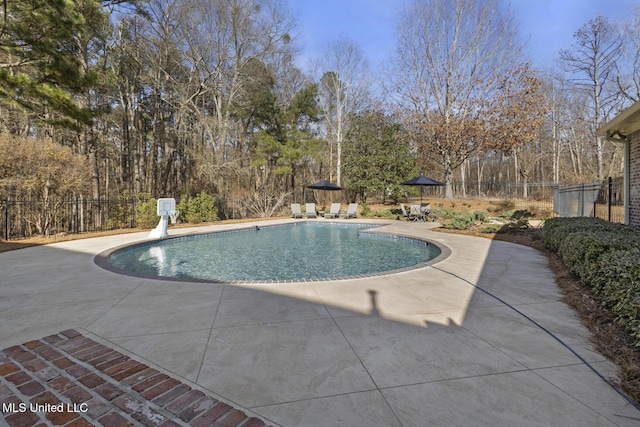 view of pool with a patio area, fence, a fenced in pool, and a water slide