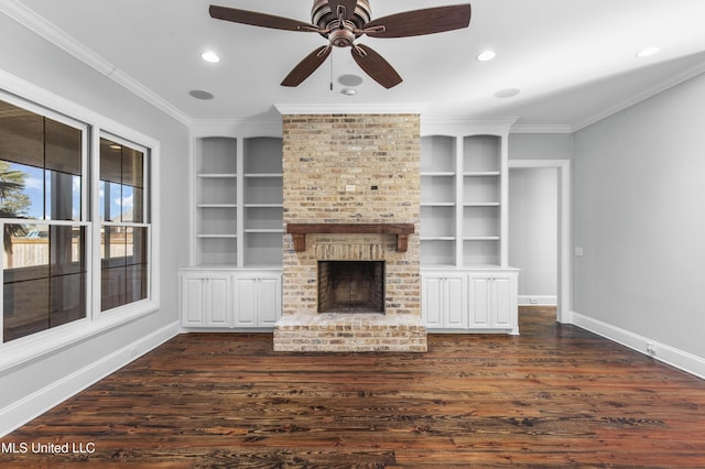 unfurnished living room featuring crown molding, a brick fireplace, built in shelves, and dark hardwood / wood-style floors