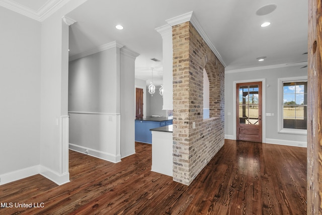 entrance foyer with a notable chandelier, crown molding, and dark wood-type flooring