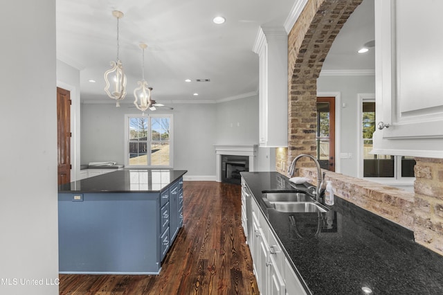 kitchen featuring dark hardwood / wood-style flooring, sink, hanging light fixtures, and white cabinets